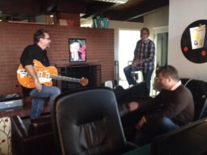 Carson Block, David Puckett and Kevin Wright collaborating at Cohere over a new guitar.
