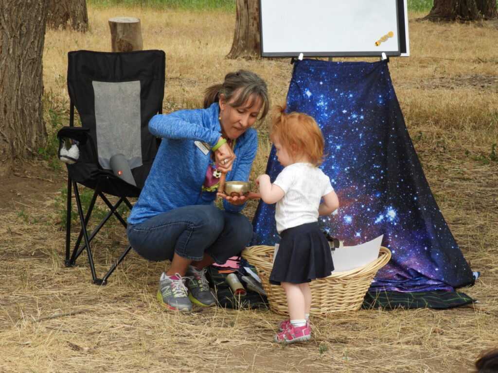 Librarian Amy Holzworth at outdoor storytime with a little girl