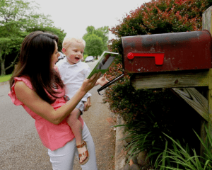 woman and young child getting abook from the mailbox