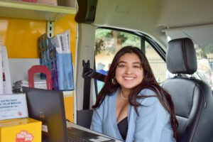 girl smiling inside a car, sitting in the driver's seat
