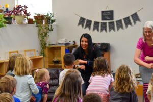 woman leading a storytime for a group of young children