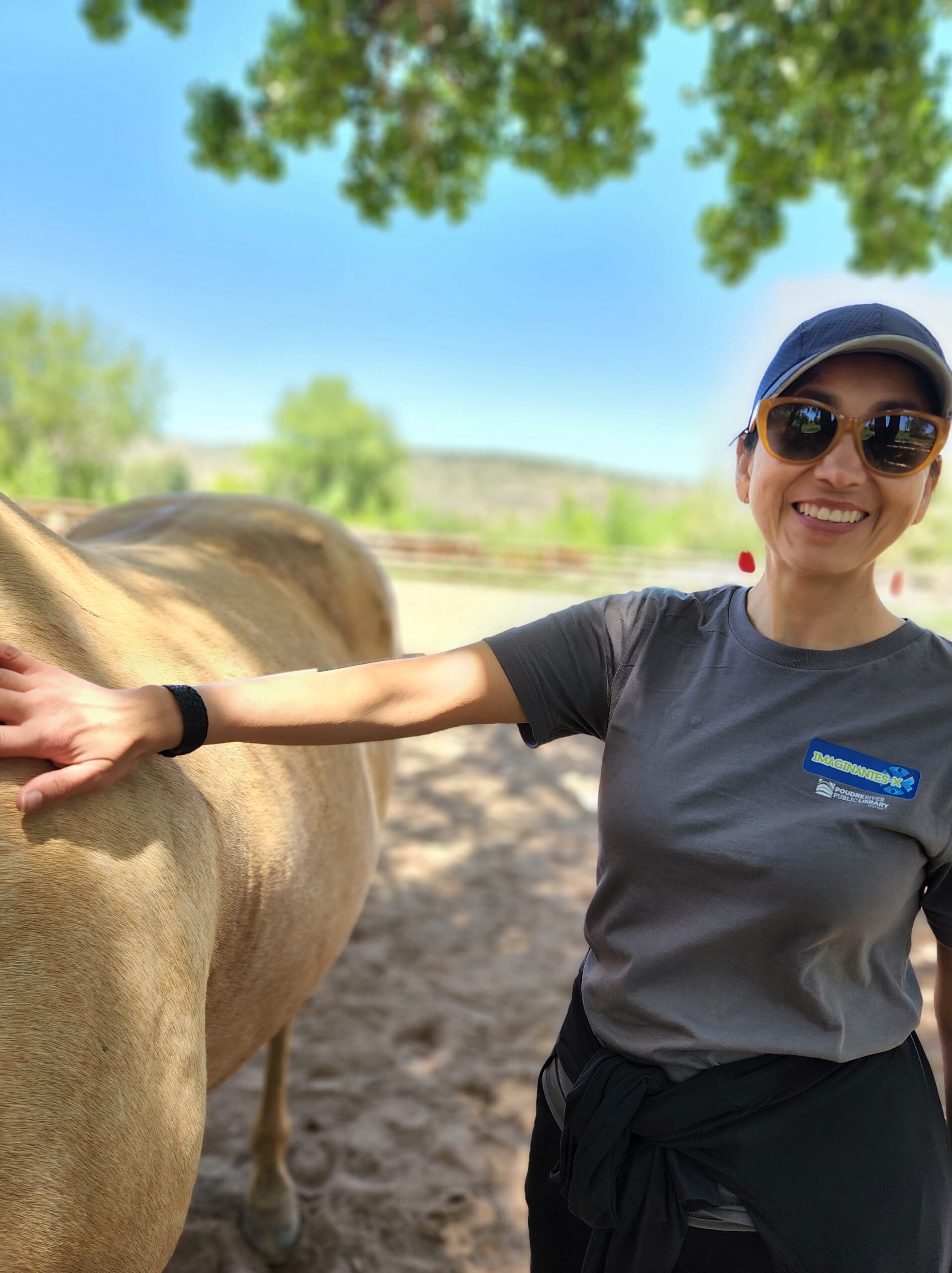 latina woman smiling while petting a horse