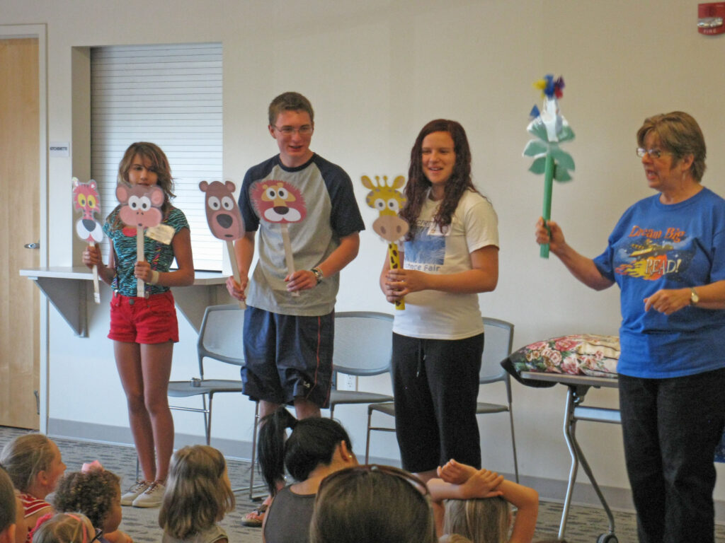 group of older children presenting to a group of younger children